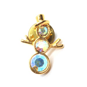 May include: A gold-toned snowman pin with three iridescent crystal-like stones for the body. The snowman has a top hat and outstretched arms. The pin is set against a white background.