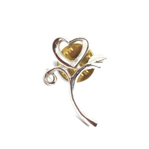 May include: Silver-toned pin featuring a stylized heart-shaped flower with a stem and leaf. The pin has a gold-toned back.