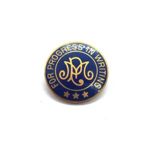 May include: A round, blue pin with gold lettering and accents. The text "FOR PROGRESS IN WRITING" encircles a central emblem. Three gold stars are at the bottom of the pin. The pin is set against a white background.