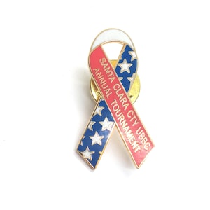 May include: A red, white and blue ribbon pin with the text "Santa Clara City USBC Annual Tournament".
