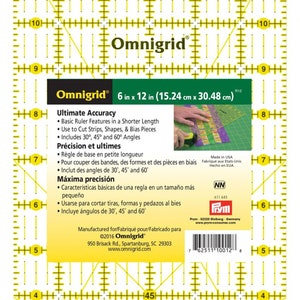 May include: A 15.24 cm by 30.48 cm Omnigrid ruler with yellow lines and markings. The ruler features 30, 45, and 60-degree angles. The ruler is made in the USA and includes the text "Ultimate Accuracy" and "Máxima precisión".