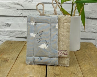 May include: Two fabric pouches with a light blue and white patterned pouch on the left and a natural linen pouch on the right. The linen pouch has a brown label with the text "The Stitched Hand".
