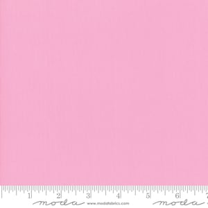 May include: A solid pink fabric swatch with a ruler showing 7 inches. The ruler has the word "moda" printed on it.