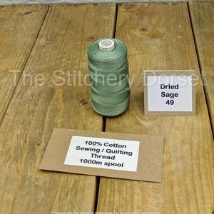 May include: A spool of 1000m sage green 100% cotton sewing and quilting thread. The spool is labeled "100% Cotton Sewing/Quilting Thread 1000m spool".