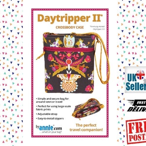 May include: A small crossbody bag with a floral print and two zippers. The bag is brown with a red zipper and a yellow strap. The text "Daytripper II" and "CROSSBODY CASE" is printed on the image.