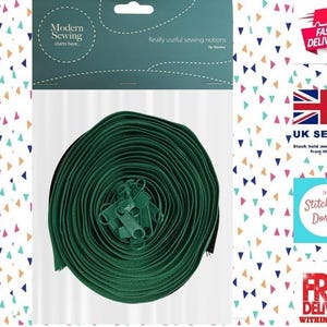 May include: A spool of dark green zipper tape, a sewing notion, is shown in a clear plastic package. The package has the text "Modern Sewing starts here." and "Really useful sewing notions".