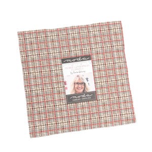 Könnte beinhalten: Ein quadratisches Stoffmuster mit einem rot-, braun- und grau karierten Muster. Der Stoff hat ein Etikett mit dem Text "Prairie Gatherings Flannels" und einem Frauenporträt. Der Stoff ist wahrscheinlich für Quilt- oder Nähprojekte.