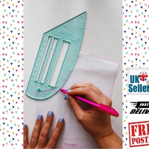 Könnte beinhalten: Eine transparente Nähschablone aus Kunststoff mit Markierungen und einer gekrümmten Kante. Eine Hand verwendet einen rosa Stift, um eine Linie auf weißen Stoff zu zeichnen.