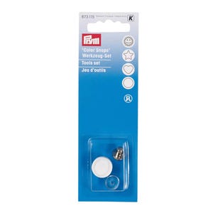 Può includere: Una confezione blu contenente un set di strumenti 'Color Snaps'. La confezione include un bottone automatico in metallo, un bottone automatico bianco e un anello di plastica trasparente. Il testo 'Color Snaps' e 'Tools set' è visibile.