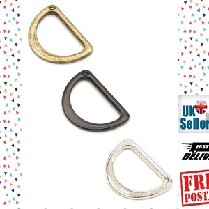 Op de afbeelding: Drie metalen D-ringen in verschillende afwerkingen: antiek messing, zwart en zilver. De ringen hebben een diameter van ongeveer 2,5 cm.