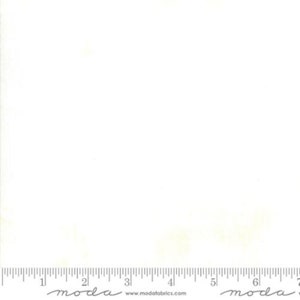 May include: A white fabric with a subtle, uneven texture. The fabric is a solid white colour with a slight sheen. The fabric is shown with a ruler for scale.