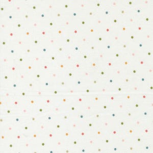 May include: Cream-coloured fabric featuring a repeating pattern of small, evenly spaced polka dots in various colours, including pink, green, blue, and yellow. The dots are scattered across the fabric.