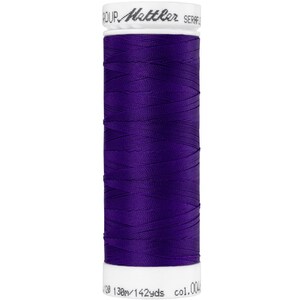 Op de afbeelding: Een spoel met paarse draad, met het label "Mettler Seraphine" en de tekst "130m/142yds col.004".