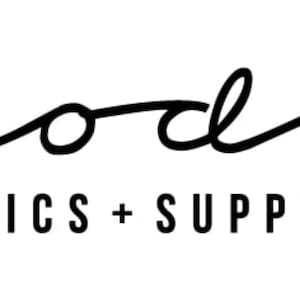 May include: Black and white logo for Moda Fabrics + Supplies. The logo features a stylized cursive script font.