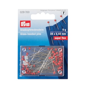 May include: A pack of 35 Prym glass-headed pins in a clear plastic container. The pins are 0.40 mm thick and are labelled "super fine".