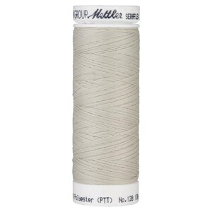 May include: A spool of light beige thread labeled "GROUP - Gütermann SERAFIL Polyester (PTT) No. 128 130m".
