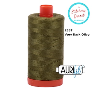 May include: A spool of dark olive green thread with the text "2887 Very Dark Olive" and "Aurifil" on the label. The spool is labelled "The Stitchery Dorset Handmade".