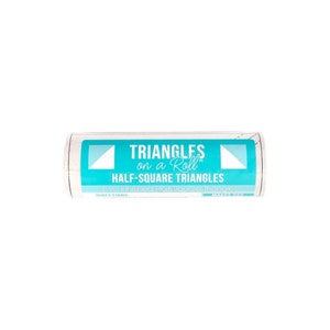 May include: A roll of white fabric with a teal label. The label reads "TRIANGLES on a Roll HALF-SQUARE TRIANGLES" with the measurement "4 1/2" Finished Half-Square Triangles". The packaging features white triangle graphics.