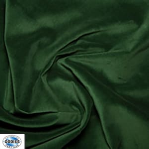 May include: A close-up of a deep green velvet fabric. The fabric is smooth and has a soft, luxurious feel.