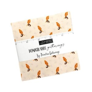 May include: A bundle of fabric squares featuring a cream backdrop adorned with a pattern of orange leaves and acorns. The fabric is wrapped with a white label that reads "PUMPKIN SPICE gatherings By: Primitive Gatherings."