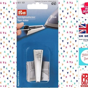Könnte beinhalten: Ein silberner Prym Schrägbandformer zum Erstellen von Schrägband. Die Verpackung zeigt den Schrägbandformer im Einsatz und enthält den Text "Schrägbandformer Tape maker" und "6 mm".