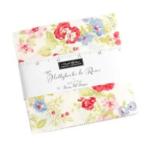 Könnte beinhalten: Ein Stapel Stoffquadrate mit einem Blumenmuster aus roten Rosen und blauen Blumen. Der Stoff ist mit einem weißen Band umwickelt, auf dem "Hollyhocks & Roses" von Bunny Hill Designs steht.