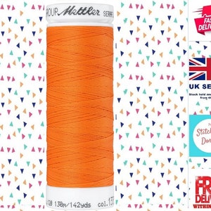 Puede incluir: Una bobina de hilo naranja con el nombre de la marca "Mattler" impreso en la etiqueta. La bobina tiene 120 metros de largo y 142 yardas. El número de color es 131.