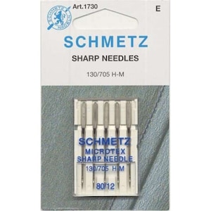 Puede incluir: Un paquete de seis agujas de coser plateadas con la etiqueta "SCHMETZ MICROTEX SHARP NEEDLE 130/705 HM 80/12".