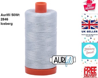 May include: A spool of Aurifil 50wt thread in the color Iceberg, a light gray shade. The spool is labeled with the brand name Aurifil and the thread weight and color number.
