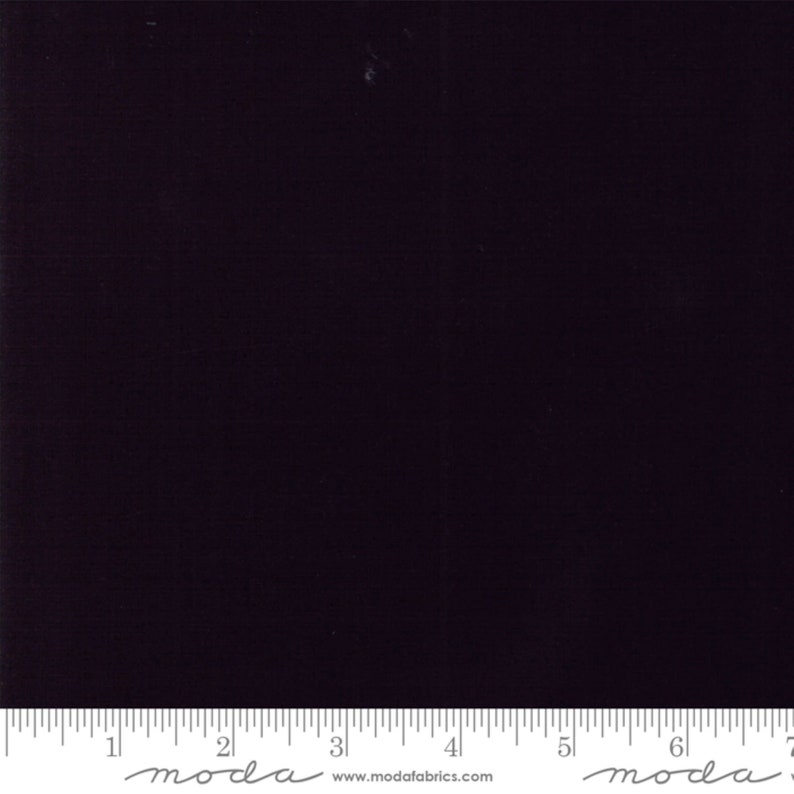 May include: A solid black fabric swatch with the text "moda" and "www.modafabrics.com" printed on a ruler at the bottom.
