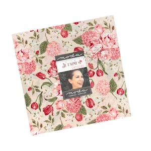 Puede incluir: Una pieza de tela cuadrada con un estampado floral de rosas rosas, tulipanes rojos y hojas verdes sobre un fondo crema. Una etiqueta rectangular está centrada sobre la tela, mostrando el texto moda, Je T'aime, Stacy Iest Hsu.