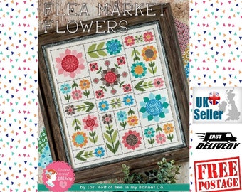 May include: A cross-stitch pattern featuring a colorful floral design with the title "Flea Market Flowers" by Lori Holt of Bee in my Bonnet Co.