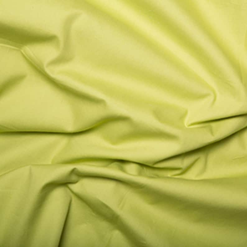 May include: A close-up of a smooth, light green fabric with soft folds and wrinkles.