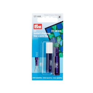 May include: A pack of 20 Prym Quilter's Premium needles in two sizes, 23/26 mm, fine and extra fine. The needles are packaged in two clear plastic tubes with purple caps. The pack is blue and white with the Prym logo and the text "new quality" repeated three times.