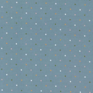 May include: A close-up of a blue fabric with a repeating pattern of small, evenly spaced polka dots. The dots are in various colors, including white, pink, green, and yellow. The fabric has a slightly textured appearance.