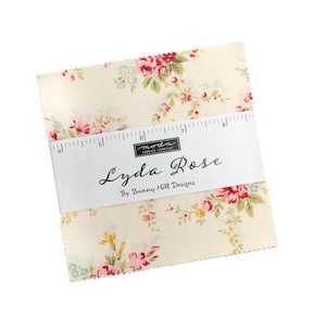 Könnte beinhalten: Ein Stapel Lyda Rose Stoffquadrate von Bunny Hill Designs. Der Stoff hat einen cremefarbenen Hintergrund mit einem Blumenmuster aus roten, rosa und gelben Rosen mit grünen Blättern. Ein weißes Band mit Produktname und Marke ist um die Quadrate gewickelt.