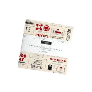 Könnte beinhalten: Ein beigefarbener Stoffquadrat mit roter und schwarzer Schrift und Illustrationen. Der Text beinhaltet "Handmade", "Quilts", "Good Day", "Made with Love" und "Go on an adventure, swim in the ocean".