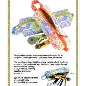 May include: Two fabric cases titled Quick Zip Cases with floral patterns in blue, green, and orange. The cases feature orange zips and carry loops. One case is shown open with a green rotary cutter and a yellow rotary cutter inside.