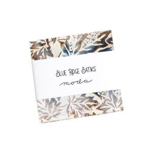 Könnte beinhalten: Ein Stoffquadrat mit einem braunen und blauen Batik-Muster. Der Stoff ist mit "Blue Ridge batiks moda" beschriftet.