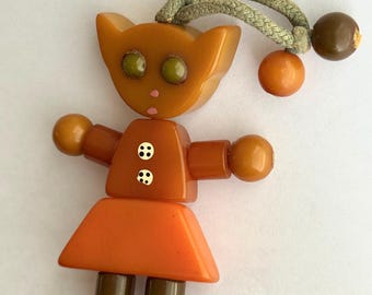 Vintage Bakelite Tykie Toy Baby Crib Toy Cat in Dress Raised Eyes