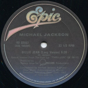 May include: Black and white vinyl record with a black and white label. The label has the text "Epic" in a stylized font, "Michael Jackson", "Billie Jean (Long Version)", "49 03557", "(XSS 169204)", "33 1/3 RPM", "6:20", "Special Version From The Epic Lp: "THRILLER" QE 38112.", "Produced by Quincy Jones for Quincy Jones Productions", "Co-produced by Michael Jackson, Publisher: Mija Music, Administered by Warner-Tamerlane Publishing Corp (BMI) 1982", "1982 CBS Inc.", "MANUFACTURED BY CBS RECORDS CANADA, LTD. T.M. OWNER "EPIC"".