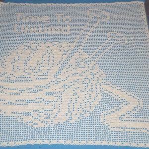 May include: A white crocheted doily with a floral design on a blue background.