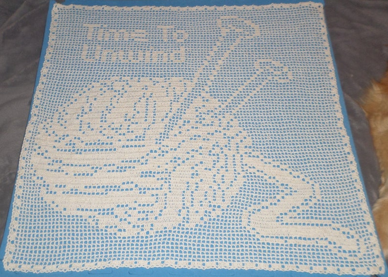 May include: A white crocheted doily with a floral design on a blue background.