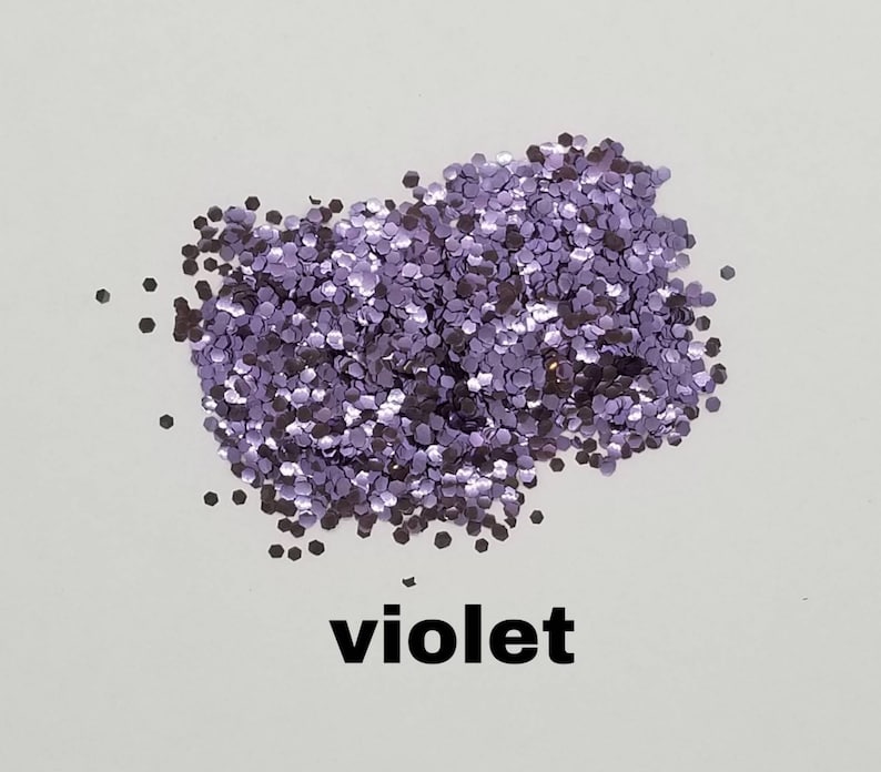 May include: A pile of loose purple glitter, with the word "violet" written below it.