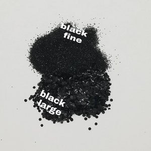 May include: Two piles of black glitter, one labeled "black fine" and the other labeled "black large".