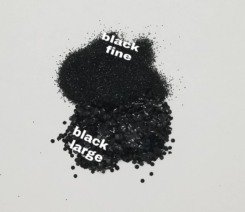 May include: Two piles of black glitter, one labeled "black fine" and the other labeled "black large".