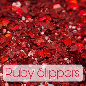 May include: Close-up of red glitter with a variety of sizes and shapes. The glitter is labeled "Ruby Slippers".