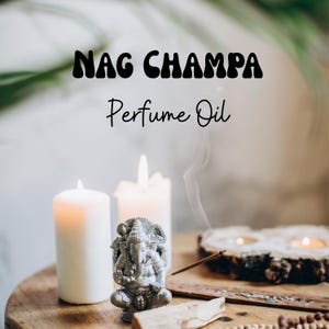 Op de afbeelding: Een Nag Champa Perfume Oil tekst staat boven een zilveren Ganesha-beeldje, twee witte stompkaarsen, een houten wierookhouder met een brandend wierookstokje en een stukje palo santo hout op een rond houten oppervlak.