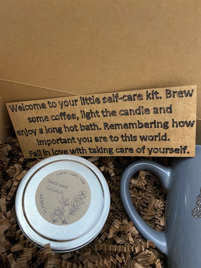 May include: A self-care kit with a gray mug, a small tin of shea and coconut body butter, and a note that reads "Welcome to your little self-care kit. Brew some coffee, light the candle and enjoy a long hot bath. Remembering how important you are to this world. Fall in love with taking care of yourself."