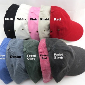 May include: A collection of baseball caps in various colors, including black, white, pink, khaki, red, blue jeans, denim, faded olive, faded red, and faded black. Each cap has a curved brim and a button on top, with the color names displayed.